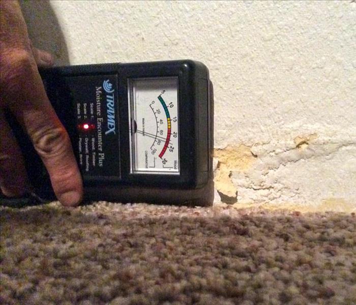 Moisture meter reading levels in wall.