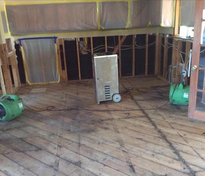 Dehumidifiers stabilizing water damaged room.